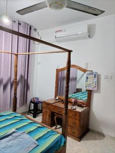 a bedroom with a bed and a dresser with a mirror at D & N Homes- Villa 1 in Kalutara