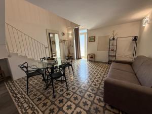 a living room with a couch and a table and chairs at Aquarius Salento in Acquarica del Capo
