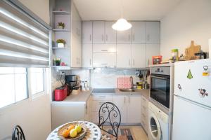 a kitchen with white cabinets and a table with fruit on it at 7th sky Aristotelous in Thessaloniki