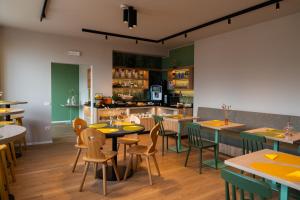 a restaurant with tables and chairs and a kitchen at Hotel al Dòs - Breakfast & Private SPA in Trento