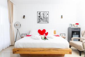 a bedroom with a white bed with red hearts on it at White House Radac Peja in Peje