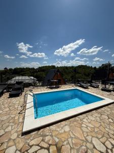 a swimming pool on top of a stone patio at Koliba Buba in Brčko