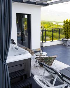 a bathroom with a tub and a chair on a balcony at White House Radac Peja in Peje