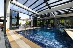 an indoor swimming pool in a house with glass walls at White House Radac Peja in Peje
