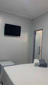 a bedroom with a bed with a flat screen tv on the wall at hOTEL CALIFORNIA in Barreiras