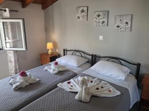 two beds with towels on them in a bedroom at Aggelos's house in Nótos
