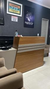 a reception desk with a television on a wall at hOTEL CALIFORNIA in Barreiras