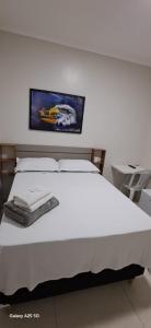 a bedroom with a white bed with a picture on the wall at hOTEL CALIFORNIA in Barreiras +50 photos