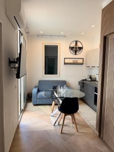 a living room with a blue couch and a glass table at Las Palomas in Santa Flavia