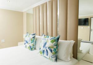 a bedroom with a bed with blue and white pillows at Kunjalo Lodge in Inadan +7 photos