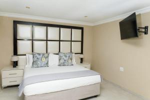 a bedroom with a bed and a tv on the wall at Kunjalo Lodge in Inadan
