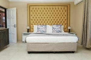 a bedroom with a large bed with a large headboard at Kunjalo Lodge in Inadan