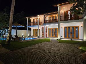 a house at night with a patio and a yard at The Blacksmith Villa in Habaraduwa Central