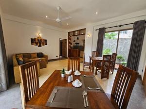 a dining room and living room with a table and chairs at The Blacksmith Villa in Habaraduwa Central