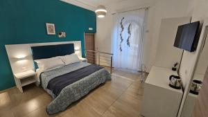 a bedroom with a bed and a blue wall at Janva Guest House in Sciacca
