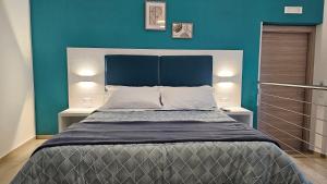 a bedroom with a large bed with a blue wall at Janva Guest House in Sciacca