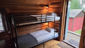 a couple of bunk beds in a room with a window at Midsommar Stuga in Årjäng