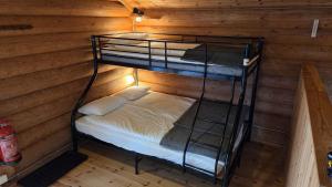 a room with two bunk beds in a cabin at Midsommar Stuga in Årjäng