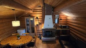 a kitchen with a table and a fireplace in a cabin at Midsommar Stuga in Årjäng