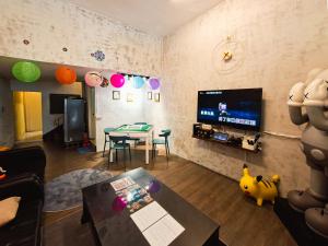 a living room with a tv and a table at Mumian Manlv Homestay in Hengchun South Gate