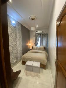 a bedroom with a bed and a table in it at La Bienveillance in Brazzaville