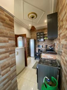 a kitchen with a stove and a refrigerator at La Bienveillance in Brazzaville