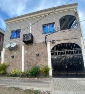 a brick building with two gates with blue windows at La Bienveillance in Brazzaville