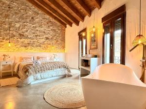 a bedroom with a bed and a stone wall at ruralhome sanroque in Altura