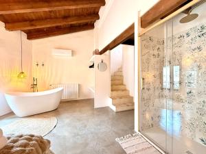 a bathroom with a tub and a glass shower stall at ruralhome sanroque in Altura +40 photos