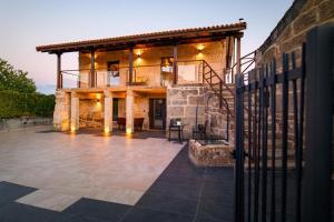 a stone house with a patio in front of it at CASA VACACIONAL ACIO in Ourense