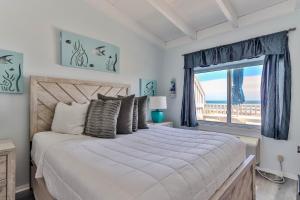 a bedroom with a large bed and a window at Sea Crest in Amagansett