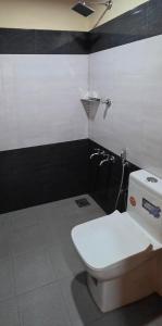 a bathroom with a toilet and a black and white wall at Dewdrops Poolvilla in Meppādi