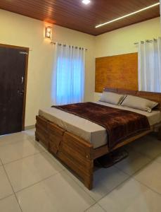a bedroom with a large wooden bed in a room at Dewdrops Poolvilla in Meppādi