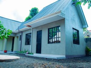 a house with black windows and a roof at Umoja Backpacker's Stay in Msaranga