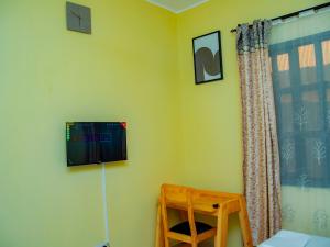 a room with a flat screen tv on the wall at Umoja Backpacker's Stay in Msaranga