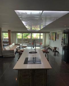 une cuisine avec évier et un salon dans l'établissement Ecologe, à Abidjan