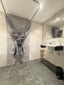 a bathroom with a sink and a shower curtain at Huus Bellevue in Gleisweiler +34 photos