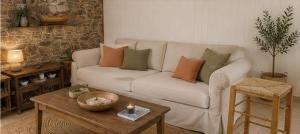 a living room with a white couch and a table at Aegina Breeze House in Egina +17 photos