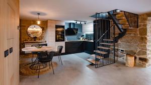 a kitchen with a spiral staircase and a table and chairs at CASA VACACIONAL ACIO in Ourense