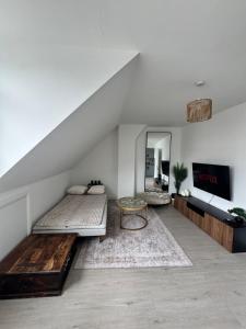 a attic room with two beds and a tv at Ultra cozy in Brookmans Park