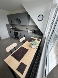 a kitchen with a table and chairs and a clock at Ultra cozy in Brookmans Park +5 photos