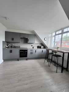 a kitchen with white cabinets and a table with chairs at Ultra cozy in Brookmans Park