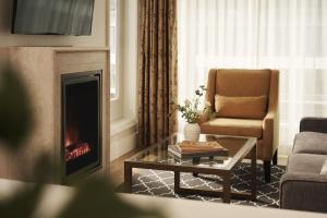 a living room with a fireplace and a chair at L'Hermitage Hotel in Vancouver