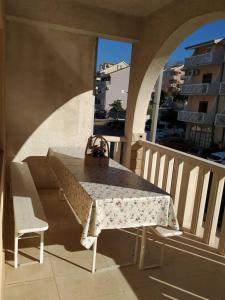 a table and chairs on a balcony with a table and a purse at toni in Makarska