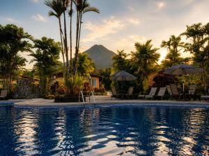 a resort swimming pool with a mountain in the background at Hotel Villas Vilma in Fortuna