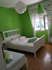 two beds in a green room with two windows at toni in Makarska