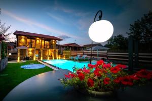 a house with a swimming pool and a yard with red flowers at CASA VACACIONAL ACIO in Ourense