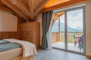 a bedroom with a bed and a balcony with a view at Dolomites Chalet Wolf in Molveno