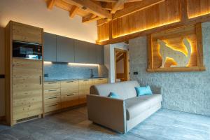 a living room with a couch and a kitchen at Dolomites Chalet Wolf in Molveno