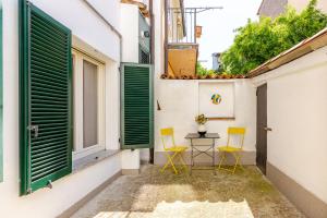 a small courtyard with two chairs and a table in a building at Dimora Pia in Piacenza
